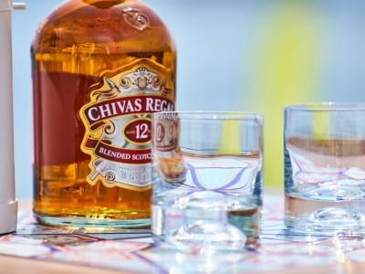 butelka whiskey Chivas Regal i dwie puste szklanki